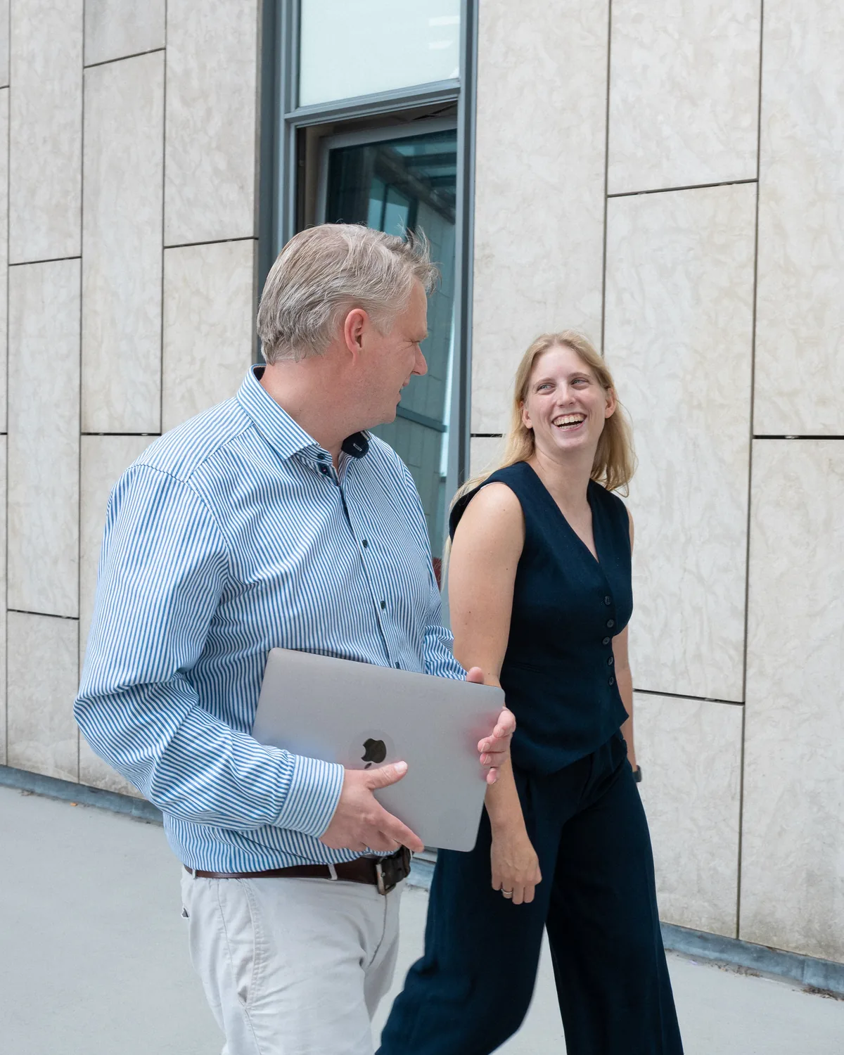 Twee collega's van PROMPTED in gesprek voor het kantoor in Groningen
