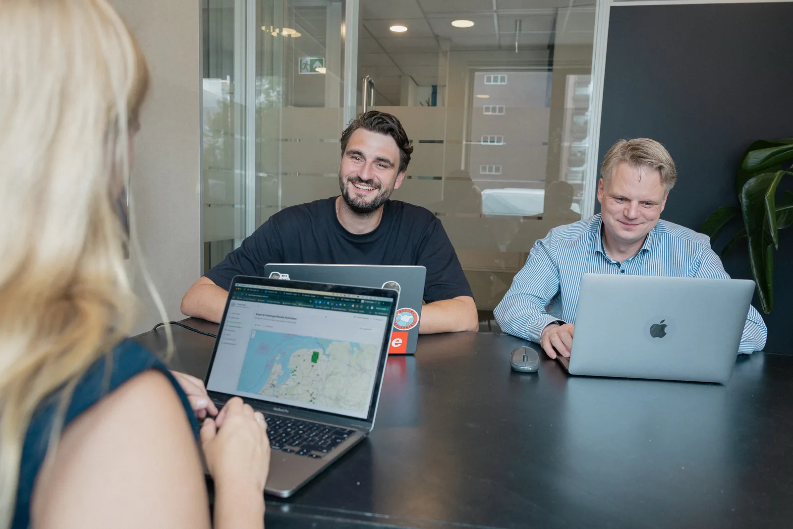 Overleg bij PROMPTED met laptops en een dashboard op het scherm